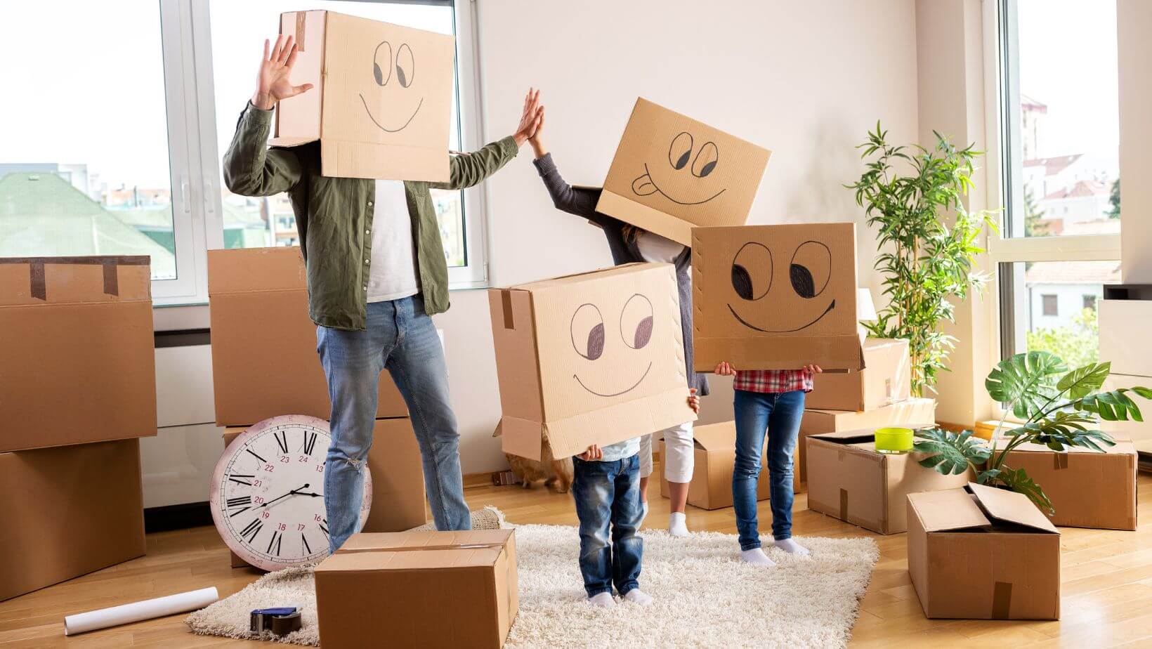 A family surrounded by boxes and have boxes on their heads with smiley faces.